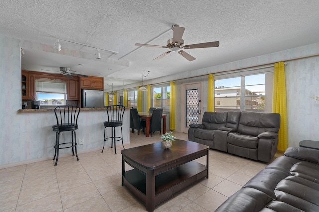 tiled living room featuring ceiling fan and a textured ceiling