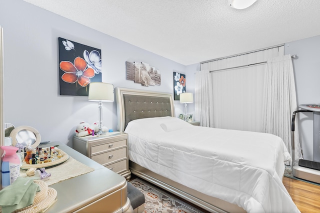 bedroom with wood-type flooring and a textured ceiling