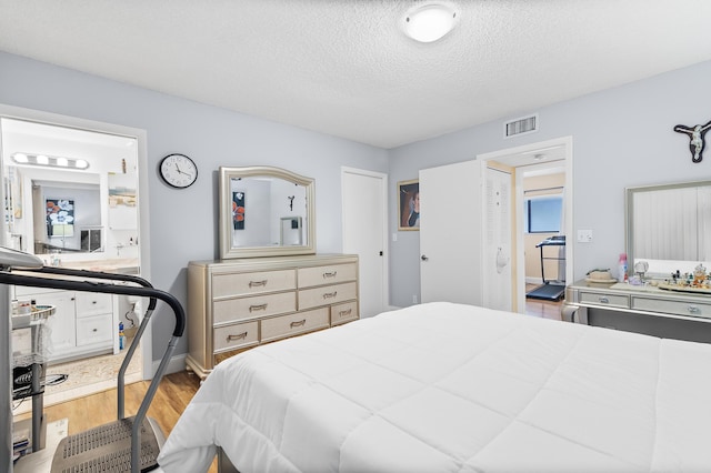 bedroom with light hardwood / wood-style flooring and a textured ceiling