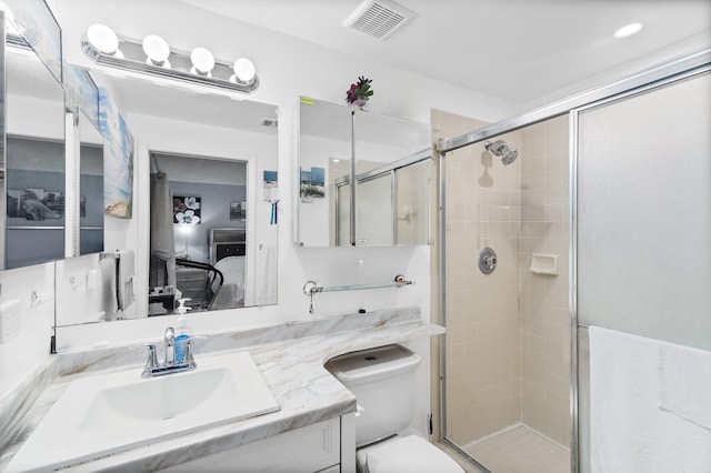 bathroom with a shower with door, vanity, and toilet