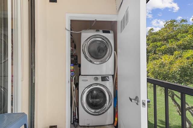 laundry area featuring stacked washing maching and dryer and plenty of natural light