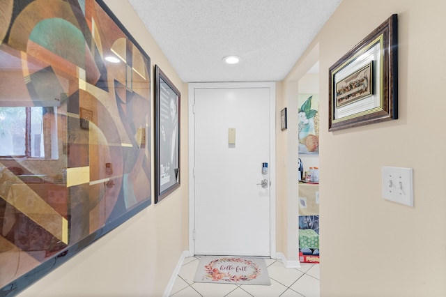 entryway with light tile patterned floors and a textured ceiling