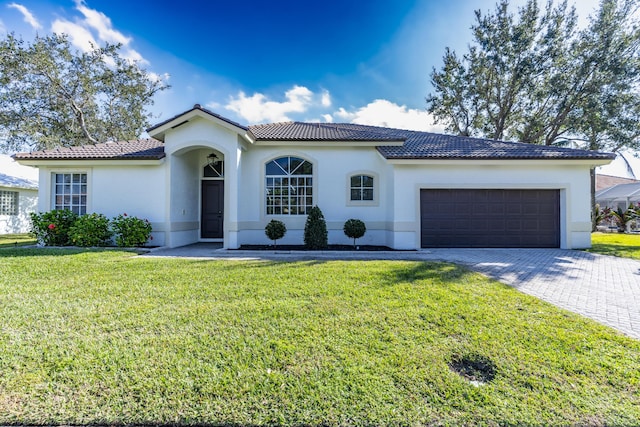 mediterranean / spanish-style house featuring a garage and a front lawn