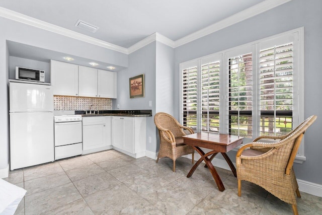 kitchen featuring sink, white cabinets, decorative backsplash, crown molding, and white appliances