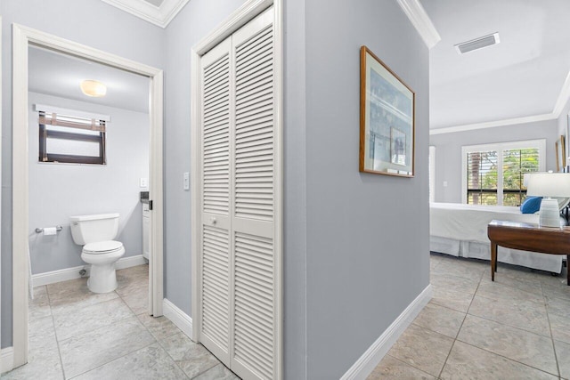 bathroom featuring tile patterned flooring, ornamental molding, and toilet