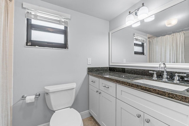 bathroom featuring vanity, a wealth of natural light, and toilet