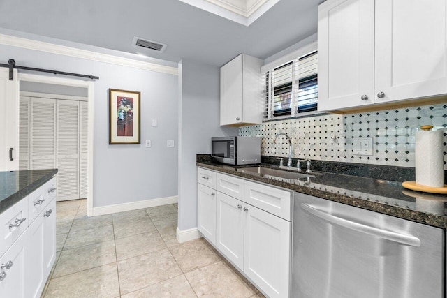 kitchen with white cabinets, stainless steel appliances, sink, and dark stone counters