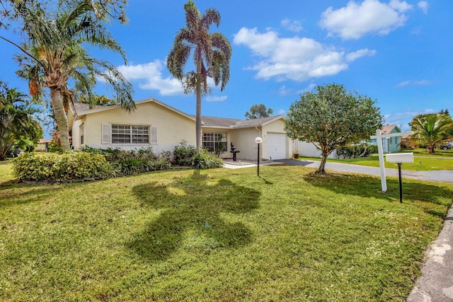 single story home with a garage and a front lawn