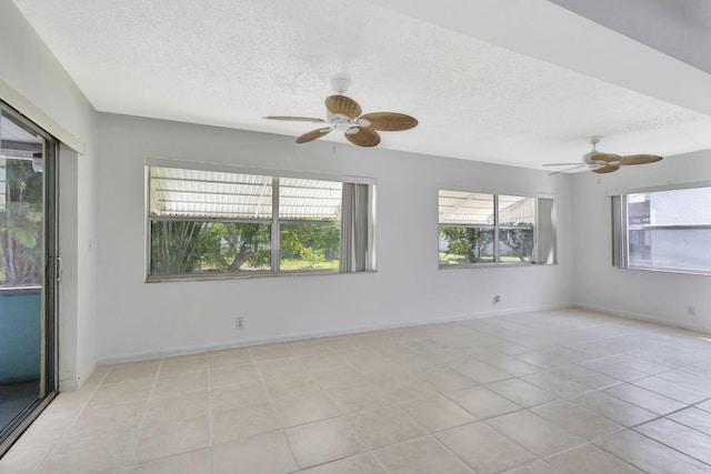 tiled empty room with ceiling fan and a textured ceiling