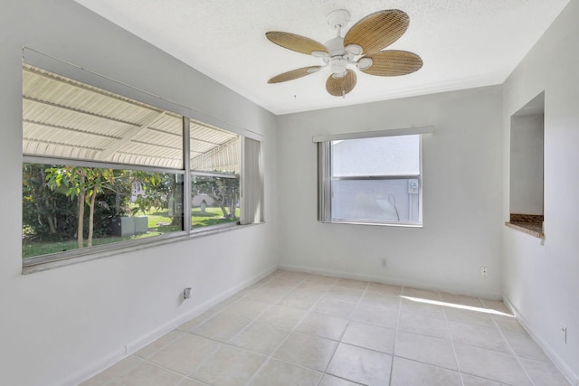 tiled spare room with a textured ceiling and ceiling fan