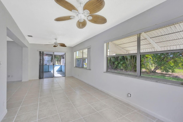 tiled spare room with ceiling fan