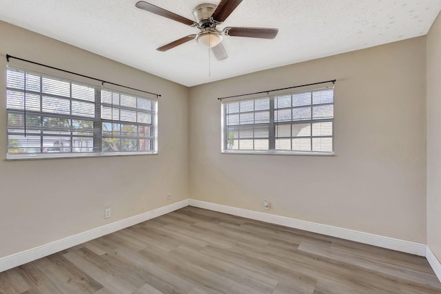 empty room with a textured ceiling, ceiling fan, and light wood-type flooring