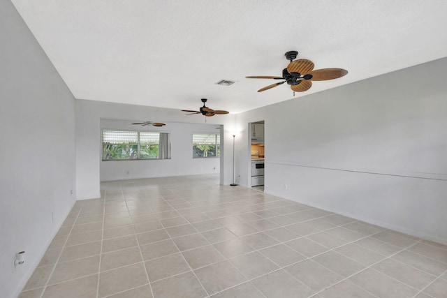 tiled spare room featuring a textured ceiling