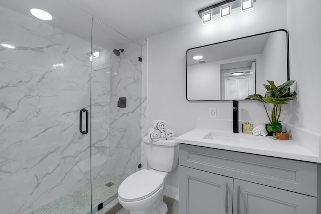 bathroom with vanity, toilet, and a shower with shower door