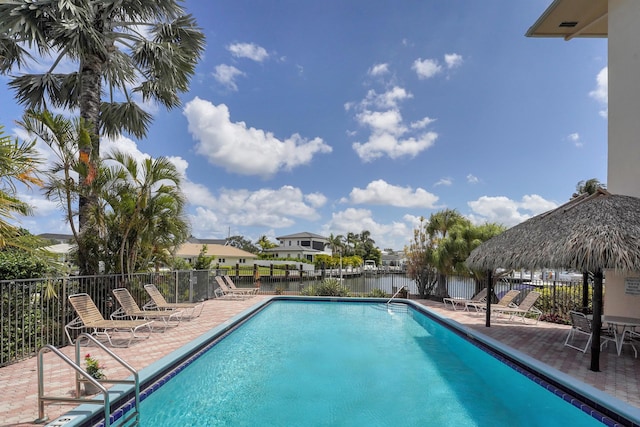 view of swimming pool with a gazebo, a water view, and a patio area