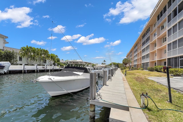 dock area with a water view and a yard