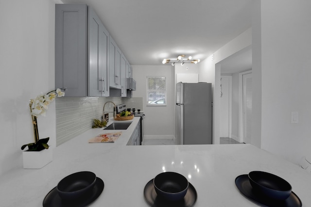 kitchen with tasteful backsplash, appliances with stainless steel finishes, and sink