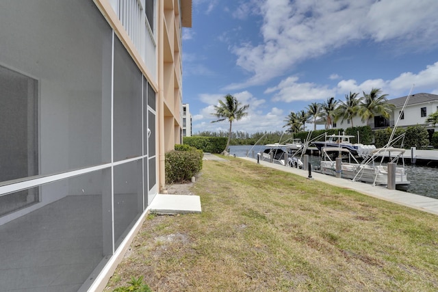 view of yard with a water view and a boat dock