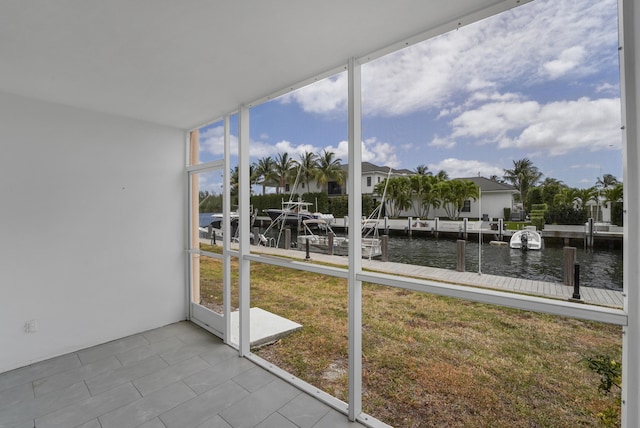 unfurnished sunroom featuring a water view