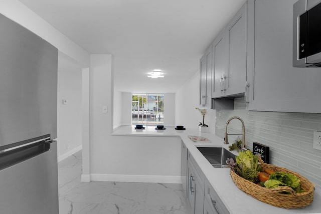 kitchen with appliances with stainless steel finishes, sink, and backsplash