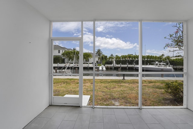 unfurnished sunroom featuring a water view