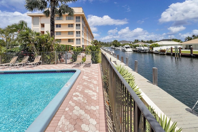 view of swimming pool featuring a dock and a water view