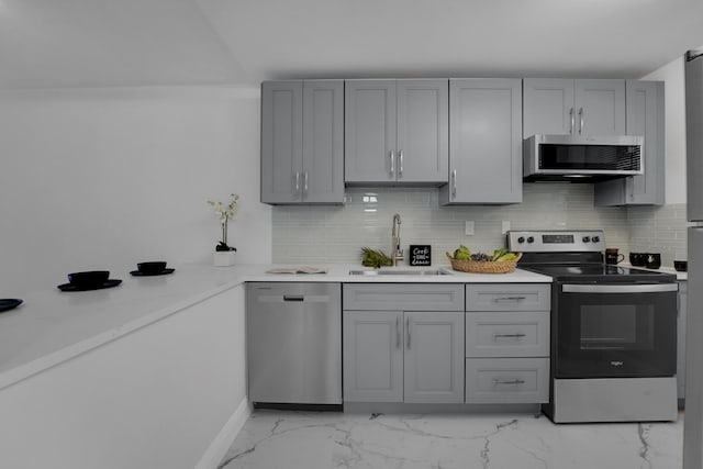 kitchen featuring tasteful backsplash, sink, gray cabinets, and stainless steel appliances