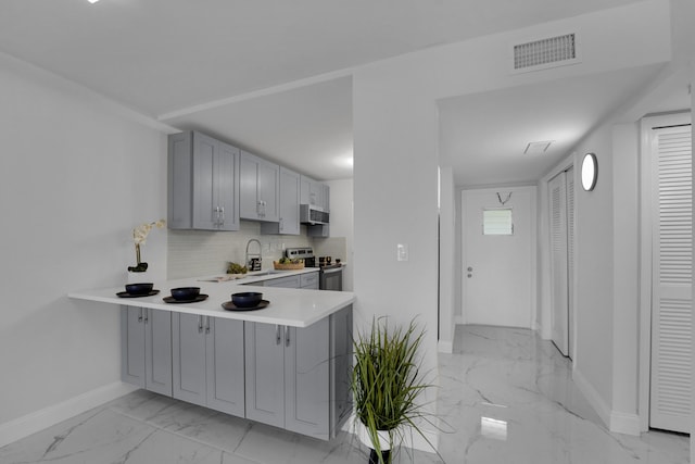 kitchen featuring sink, gray cabinets, electric range, tasteful backsplash, and kitchen peninsula