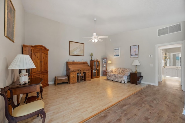 living room featuring ceiling fan and light hardwood / wood-style flooring