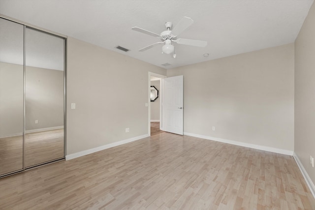 unfurnished bedroom featuring a closet, ceiling fan, and light wood-type flooring