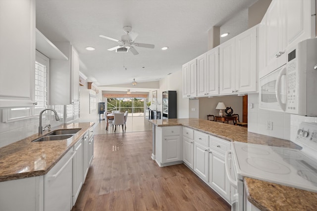 kitchen featuring sink, light stone counters, kitchen peninsula, white appliances, and white cabinets