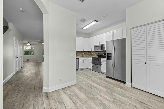 kitchen featuring tasteful backsplash, white cabinetry, ceiling fan, light hardwood / wood-style floors, and stainless steel appliances