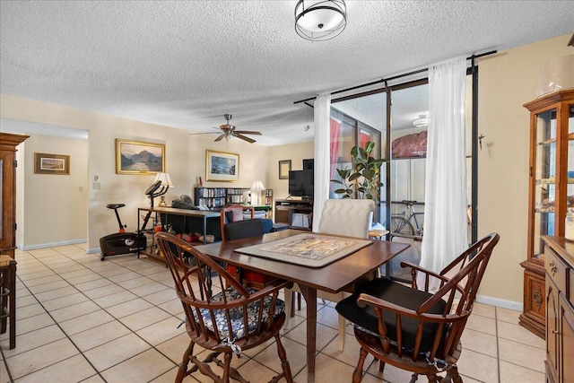 tiled dining space featuring a textured ceiling, a wall of windows, and ceiling fan