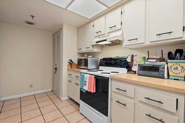 kitchen featuring white cabinetry, light tile patterned floors, and electric stove