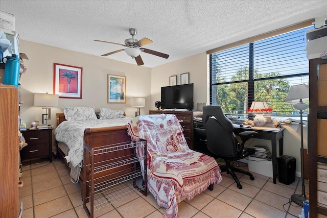 tiled bedroom with ceiling fan and a textured ceiling