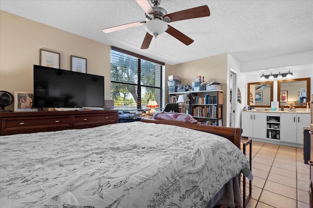 tiled bedroom with ceiling fan, ensuite bathroom, and a textured ceiling