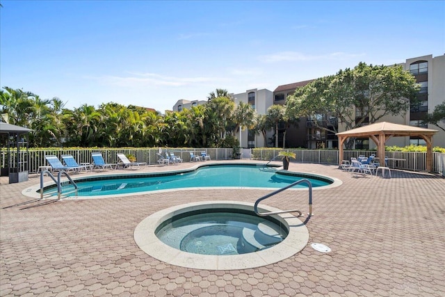 view of swimming pool featuring a community hot tub, a patio, and a gazebo