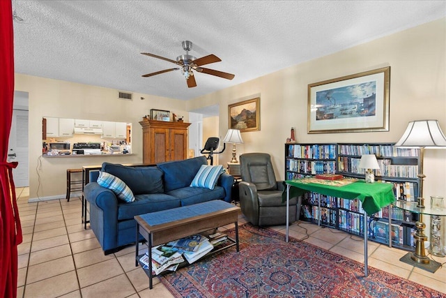 tiled living room featuring a textured ceiling and ceiling fan