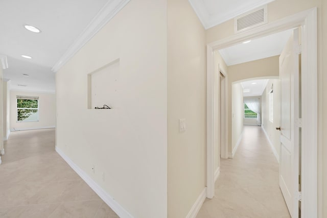 hall featuring crown molding, plenty of natural light, and light tile patterned flooring