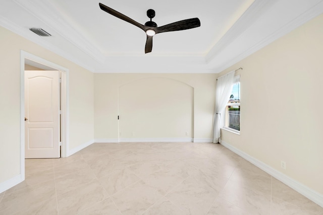 spare room with crown molding, ceiling fan, and a raised ceiling