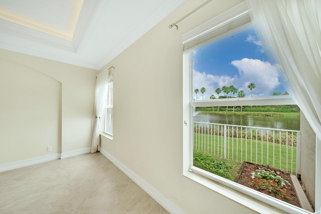 interior space with a raised ceiling and a water view