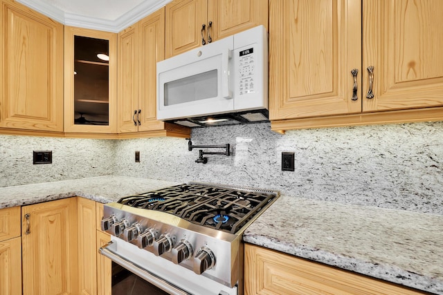 kitchen featuring high end stainless steel range oven, tasteful backsplash, and light stone counters