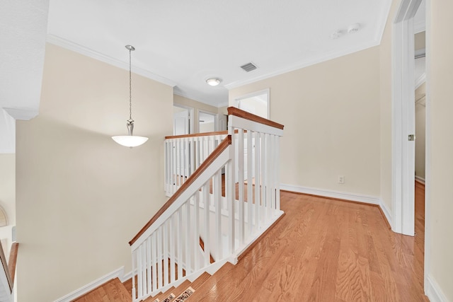 hallway featuring ornamental molding and light wood-type flooring