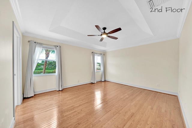 unfurnished room featuring crown molding, ceiling fan, a raised ceiling, and light hardwood / wood-style floors