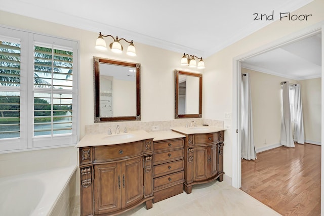 bathroom featuring vanity, a washtub, crown molding, and wood-type flooring