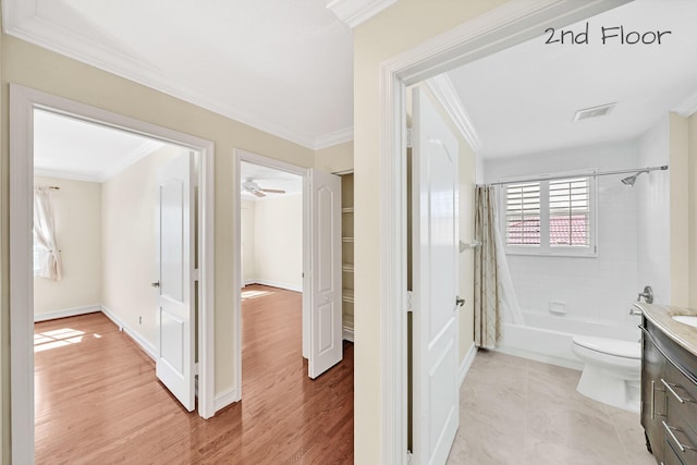 full bathroom featuring vanity, shower / bath combination with curtain, crown molding, and toilet