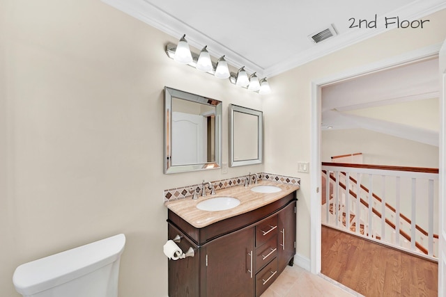 bathroom with ornamental molding, toilet, and vanity