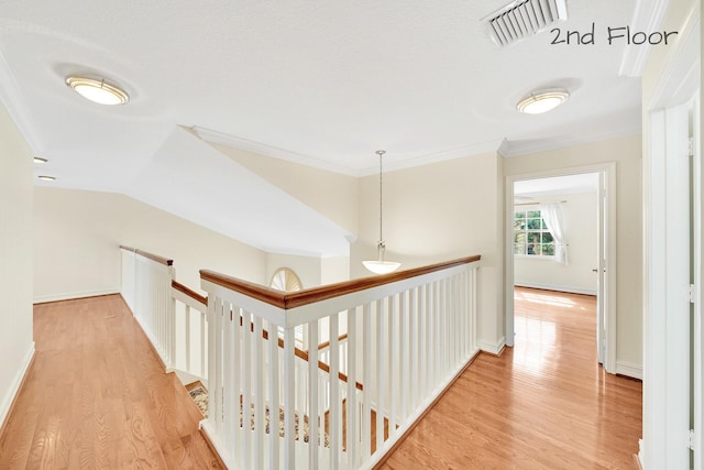 corridor featuring ornamental molding and light hardwood / wood-style floors