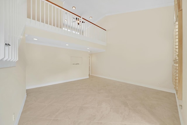 spare room with crown molding, light tile patterned flooring, and high vaulted ceiling