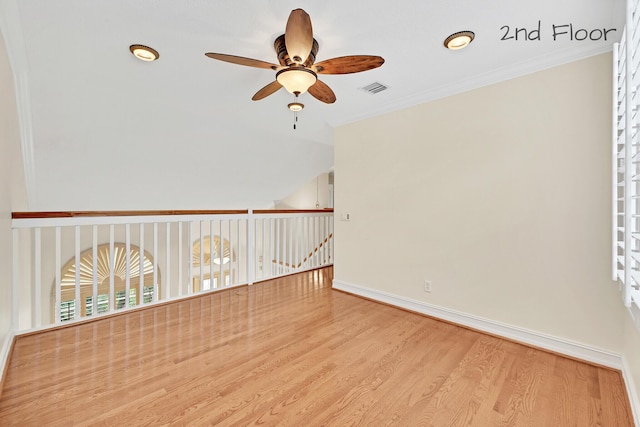 spare room with ornamental molding, lofted ceiling, ceiling fan, and light hardwood / wood-style flooring